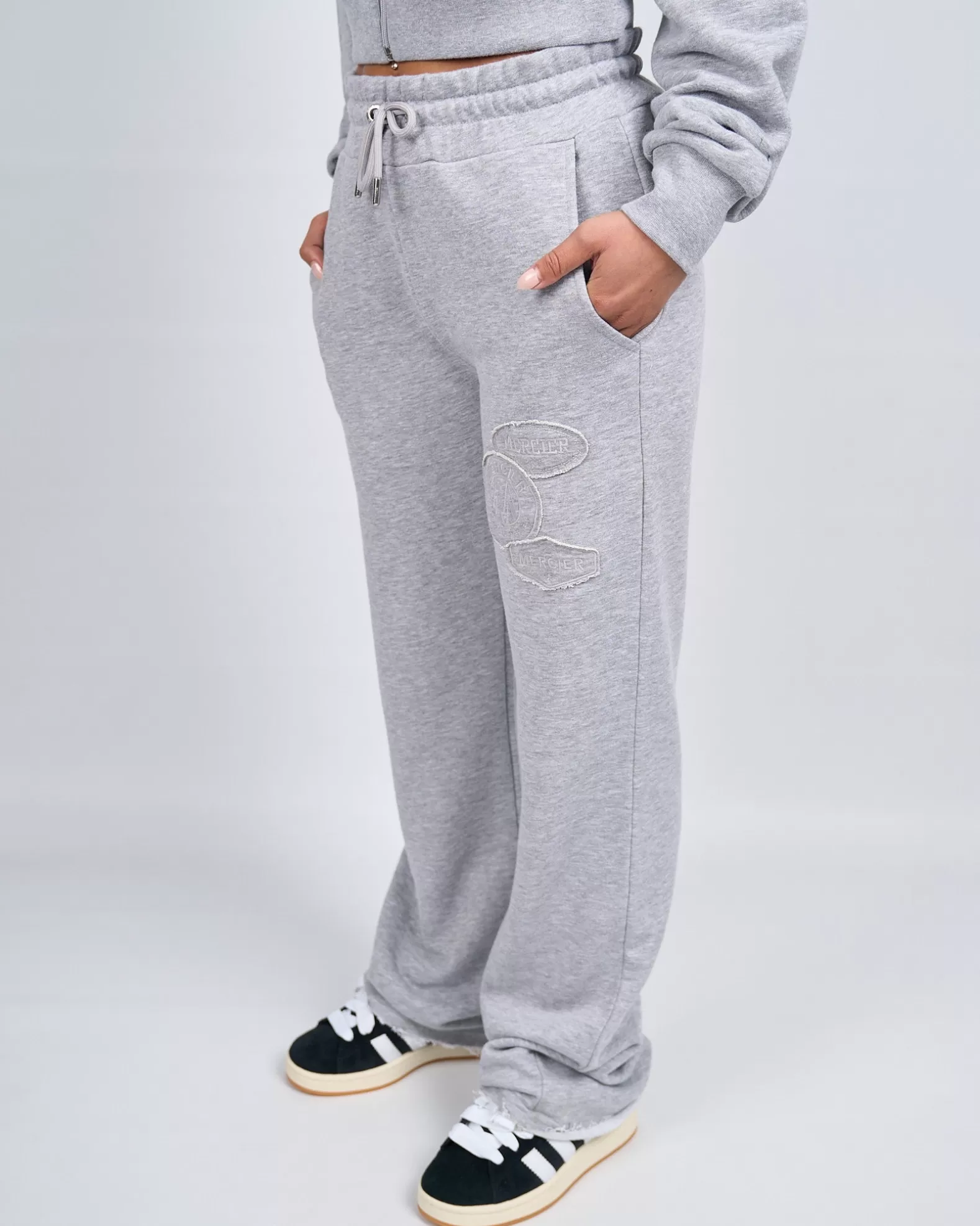 womens_grey_marl_og_badge_raw_joggers_3.webp Shop Mercier Womens Grey Marl OG Badge Raw Joggers